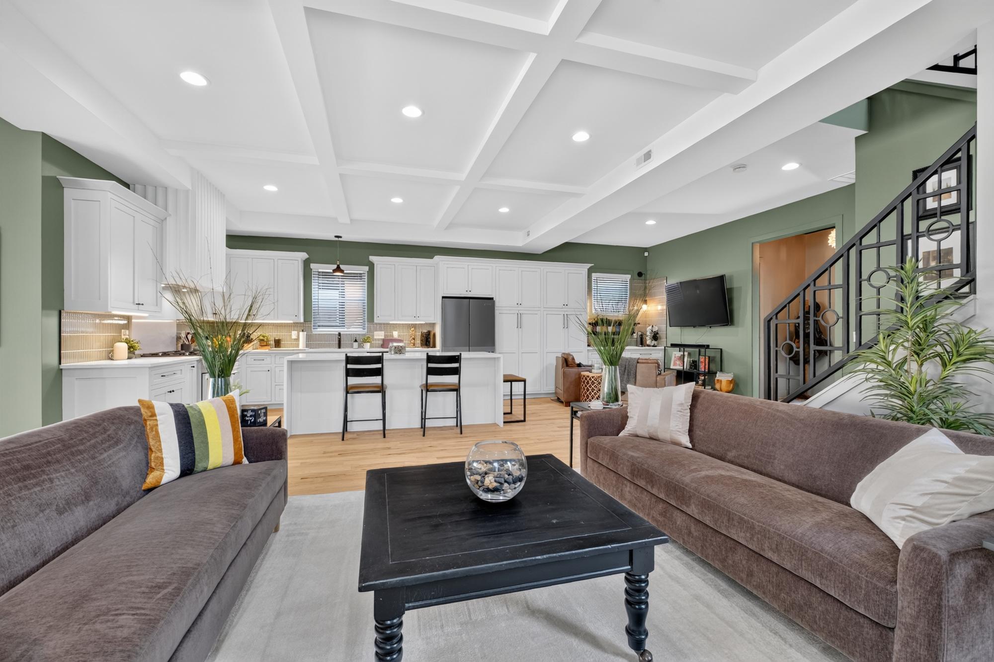 Great room with gray walls, white coffered ceiling and sage green walls beyond